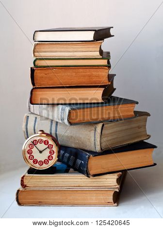 analog retro alarm clock on a heap of old books
