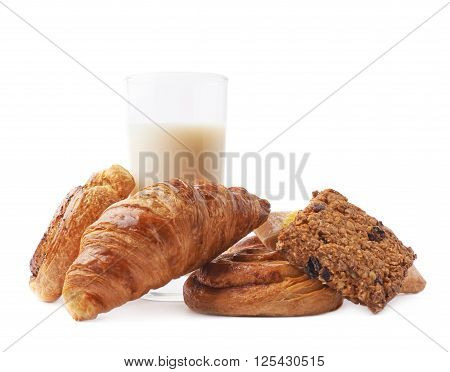 Multiple sweet bread pastry buns next to the glass of milk, composition isolated over the white background