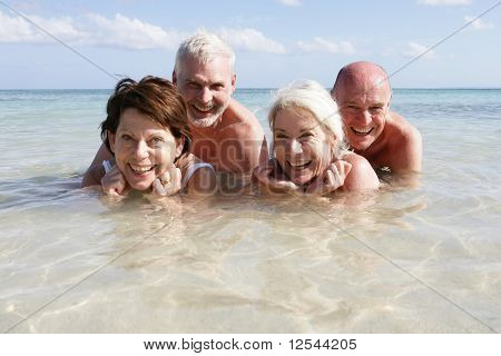 Portret van een groep van lachende senioren badend in de zee