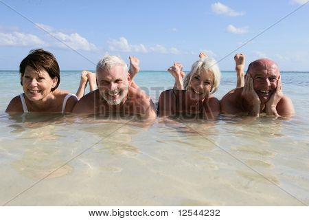 Portret van een groep van lachende senioren badend in de zee
