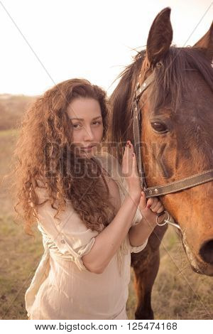 Beautiful girl with a horse outdoors in the countryside.
