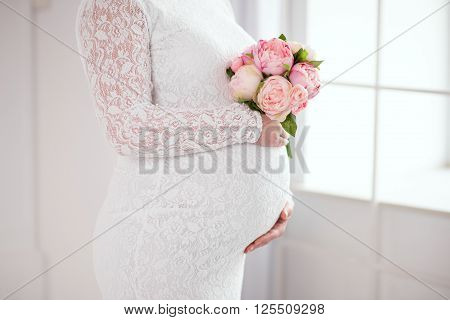 Pregnancy. Belly of a pregnant girl. Hands on the belly.