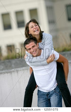 Retrato de um jovem sorridente, carregando uma mulher jovem