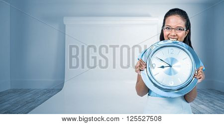Delighted businesswoman holding a clock against large white screen