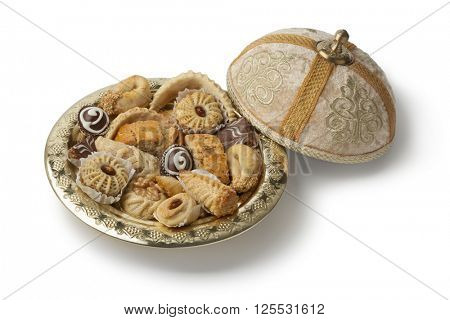 Traditional Moroccan festive cookies on a metal tajine on white background