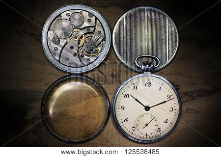 Old russian pocket watch inside and covers on wooden table