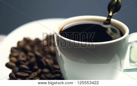 White Cup Black Coffee On Background Of Beans