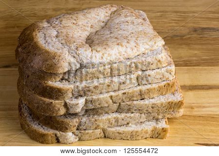 Stack of wholemeal bread slices on a wooden bread board