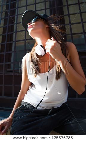 A beautiful young Hip Hop Rapper girl with Headphones in a urban environment.