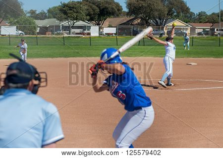 Softball pitcher winding up to throw the curve ball to the batter.