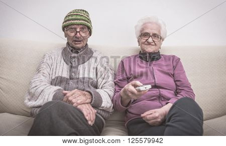 Old couple and zapping. senior couple watching television on the couch