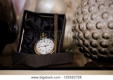 Black box with golden pocket watch on chain