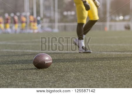 Ball and American football player on the green grass field