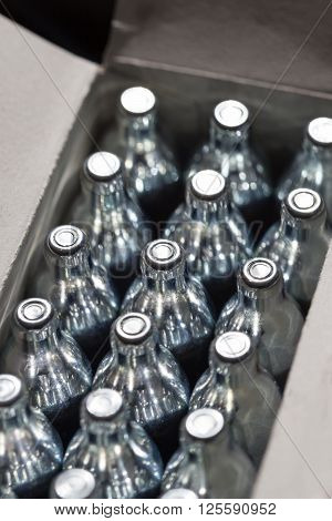 Soda chargers in carton box. Selective DOF, cole up shot.