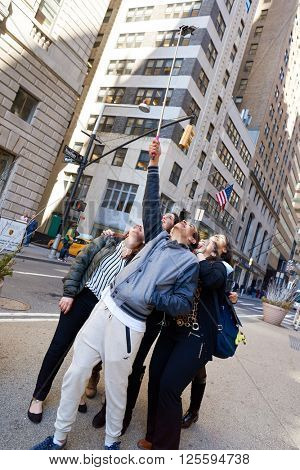 NEW-YORK - CIRCA MARCH 2016: people taking a selfie in New-York. A selfie is a self-portrait photograph, typically taken with a camera phone held in the hand or supported by a selfie stick.