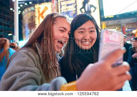 NEW-YORK - CIRCA MARCH 2016: women taking a selfie in New-York. A selfie is a self-portrait photograph, typically taken with a camera phone held in the hand or supported by a selfie stick.
