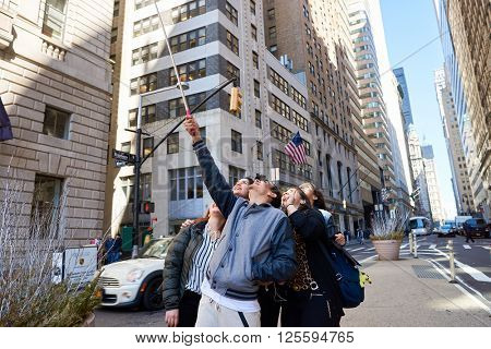 NEW-YORK - CIRCA MARCH 2016: people taking a selfie in New-York. A selfie is a self-portrait photograph, typically taken with a camera phone held in the hand or supported by a selfie stick.