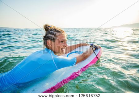 Young surfer girl is lerning to ride a wave.