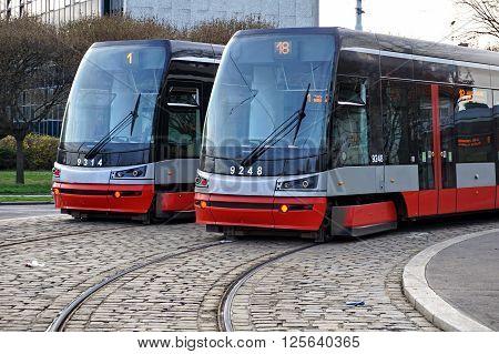 PRAGUE, CZECH REPUBLIC - CIRCA MARCH 16: Two brand new trams on the parallel cobbled tracks in Prague, Czech republic