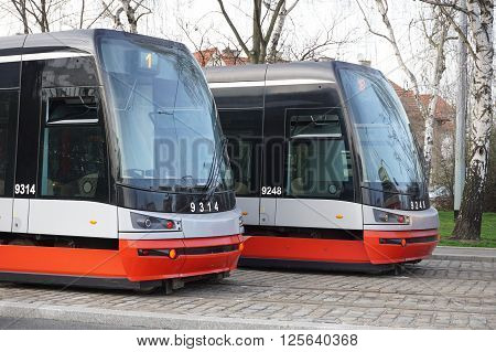 PRAGUE, CZECH REPUBLIC - CIRCA MARCH 16: Two brand new trams on the parallel cobbled tracks in Prague, Czech republic