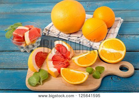 Fresh Oranges And Grapefruit On Wooden Background