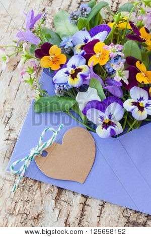 Little bouquet of spring flowers in purple envelope
