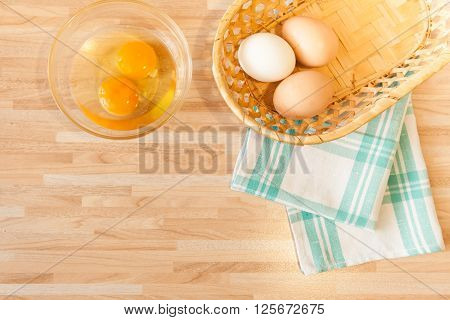 Eggs In Braided Bucket On Towel And Raw Eggs In Glass Pialat On Light Wooden Background With Copyspa