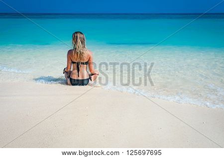 Woman with a black bikini sitting and relax on the beach Phi Phi island Krabi Thailand