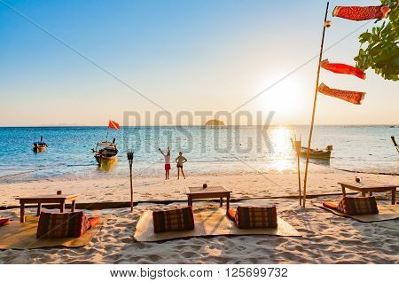 Beach in the morning with couple and traditional longtail boats in Lipe island Satun Thailand