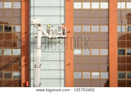 Workers is engaged in restoration of the modern multi-storey building in Helsinki, Finland