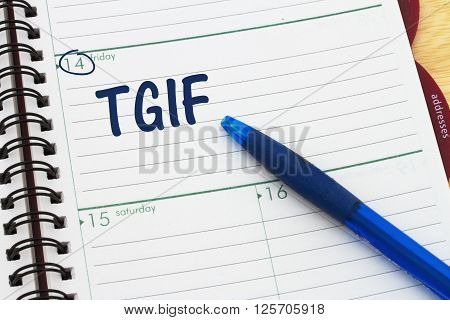 Happy it is Friday a day planner with blue pen with text TGIF