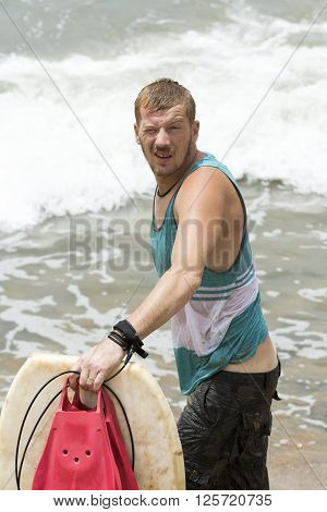 Causasian man just finished surfing on the waves Sea beach san