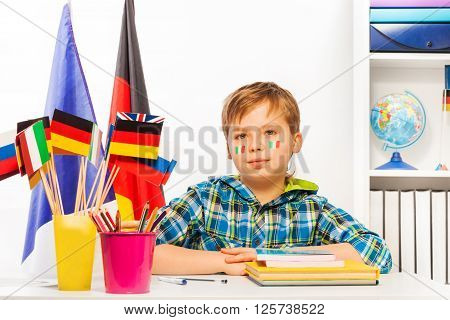 Italian schoolboy sitting at the desk on geography lesson in the classroom