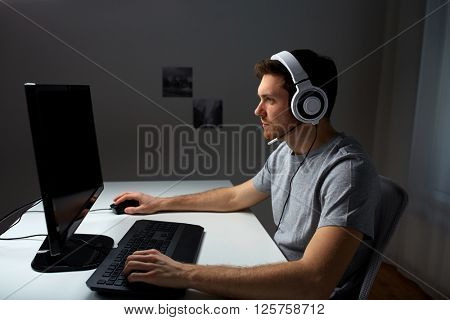 technology, gaming, entertainment, let's play and people concept - young man in headset with pc computer playing game at home and streaming playthrough or walkthrough video