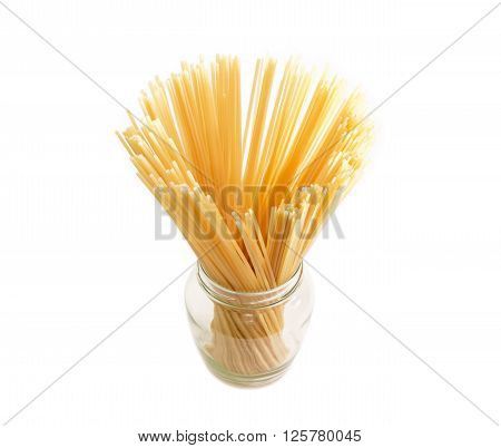 Two different varieties of uncooked dried long pasta in glass jar on a light background