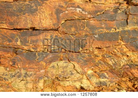 Superficie de la roca de litoral acantilado de color naranja.