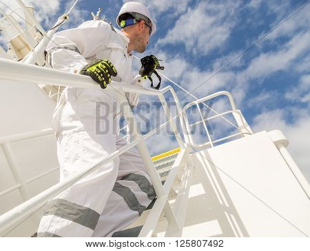 Man in white workwear with VHF standing on stairs