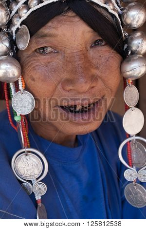 MAE SALONG,  CHIANG RAI province , THAILAND - JUN, 2004 : 
In the mountains of northern Thailand. An old woman from the Akha ethnic group. To save her money Akha women sew silver coins on headdress.