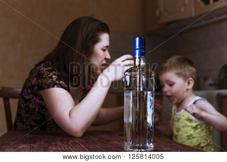 Quarrel between drunk mother and her little son. Family problems female alcoholism. Focus on bottle.
** Note: Shallow depth of field