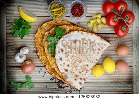 Lahmacun on a wooden table with ingredients. Turkish pizza