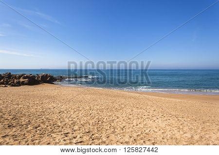Beach blue ocean horizon rocky coastline landscape.