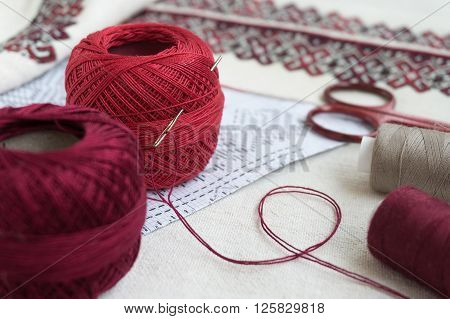 Balls of yarn on a background of embroidered fabric