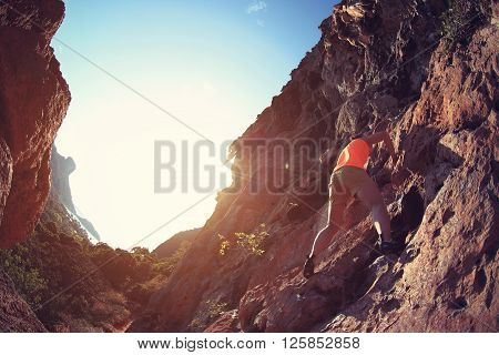 free solo woman rock climber climbing on mountain rock