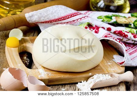 Fresh dough for bread or bun and ingredients. Concept of preparing at home selective focus