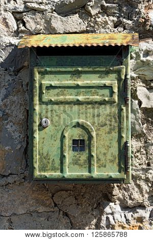 Detail of an Italian rusty metallic mailbox hanging on a wall. Portovenere Liguria Italy