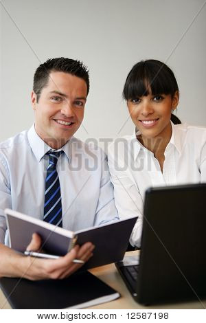 Retrato de um jovem e uma jovem sorridente na frente de um computador portátil