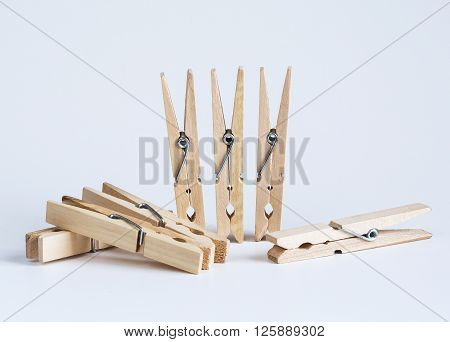 Wooden clothespins on a white batskground close-up tools