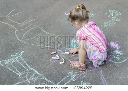 Sidewalk chalk drawings of little Caucasian girl wearing pink ruffle skirt with floral pattern