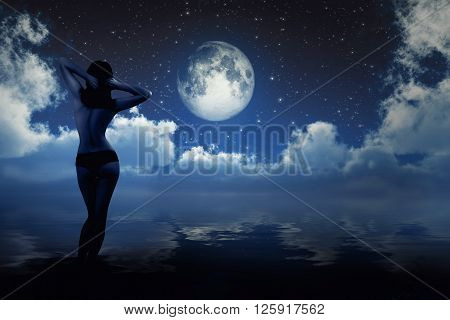 naked girl on sea beach looking at moon