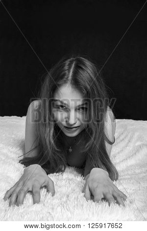 serious naked woman lying on fur with black copyspace monochrome image